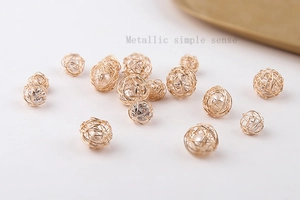 Detalle de esfera de hilo metálico dorado con perla interior para accesorios de joyería