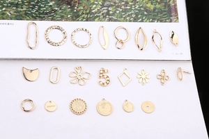 Flat lay of gold irregular alloy pendants including flower, coin, and fashion charms