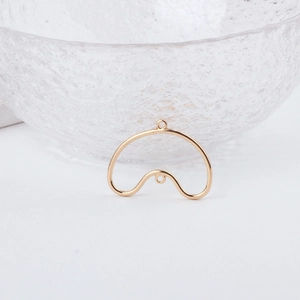 Close-up of golden wavy metal jewelry connector with dual rings for DIY earrings
