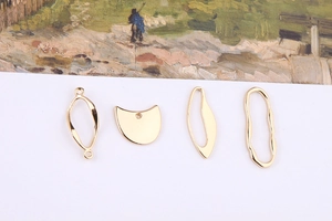 Macro shot of four irregular golden DIY jewelry pendants in various artistic shapes