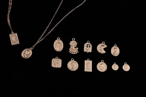 Flat lay view of vintage rose gold alloy coin pendants and relief portrait charms