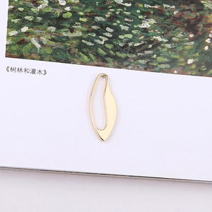 Artistic close-up of irregular golden leaf-shaped hollow metal pendant for DIY jewelry