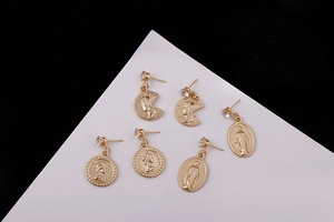 Detailed view of three vintage gold coin pendants with religious icons and clear zircons
