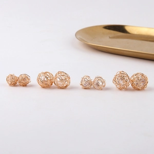 Pendientes de hilo de metal dorado con perlas y circonitas en soporte blanco