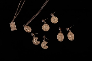 Detail of vintage gold-plated coin charms with portrait relief and rhinestone accents