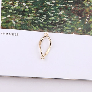 Macro shot of twisted gold metal oval link with double loops for DIY jewelry making