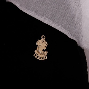 Detail of vintage gold alloy coin pendant with goddess relief and five connector loops