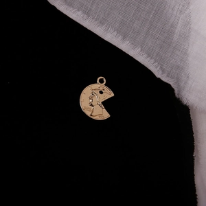 Detailed view of a vintage gold alloy coin pendant with an embossed portrait and 1974 text