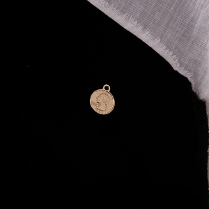 Macro view of golden vintage Liberty coin pendant with relief portrait on black background