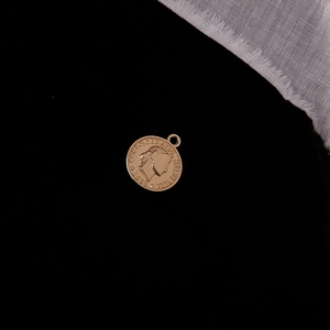 Macro shot of a vintage gold portrait coin pendant with Confoederatio Helvetica carving