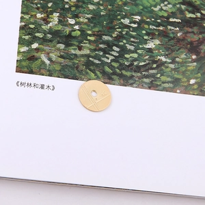 Macro view of a gold-finish round metal charm with cross patterns for DIY jewelry making