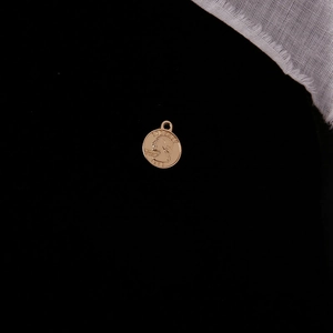 Detailed close-up of a vintage golden coin pendant featuring a 1972 embossed profile