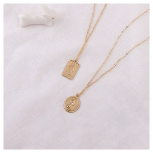 Vintage gold-plated alloy coin pendants with embossed classical portraits on white fabric