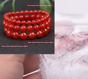 Makro-Detail von 2mm Silikon-Zwischenscheiben für DIY-Schmuck mit roten Perlen