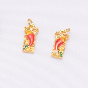Détail macro du pendentif piment doré avec nœud en émail coloré pour bijoux faits main