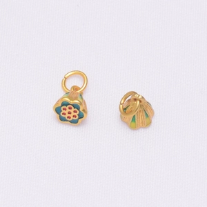 Gros plan de pendentifs en émail cloisonné doré avec motifs floraux bleus et anneaux