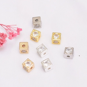 Dettaglio di distanziatori a cubo placcati oro 14K con zirconi per braccialetti fai-da-te