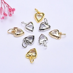Close-up of 14K gold and silver plated heart pendants with inlaid cubic zirconia