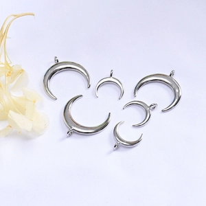 Macro view of polished crescent moon charms in various sizes for DIY jewelry making