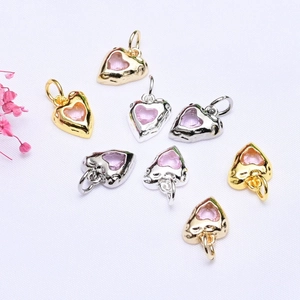 Detail of 14K gold plated heart pendants with pink cubic zirconia and hammered texture