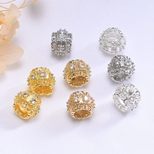 Macro shot of 14K gold hollow filigree beads with sparkling zircons for jewelry making