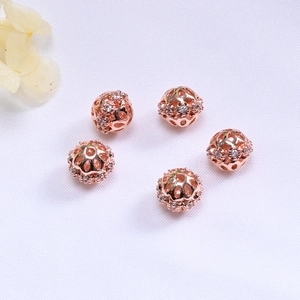 Macro view of five rose gold hollow beads with inlaid zircons for DIY jewelry making