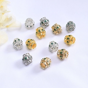 Vista macro de cuentas cilíndricas de oro de 14K con cristales verdes para joyería