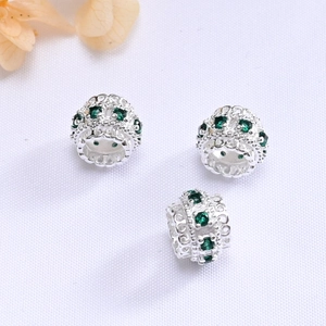 Detailed view of three 10mm gold-plated lace beads with green crystals for DIY bracelets