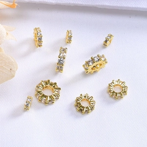 Detalle macro de cuentas espaciadoras bañadas en oro de 14K con circonitas para joyería DIY