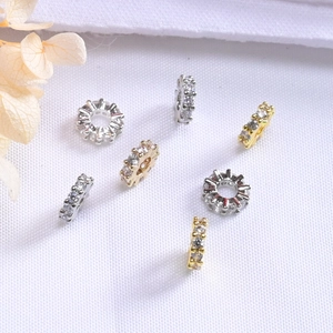 Vista macro de cuentas espaciadoras bañadas en oro de 14K con circonitas brillantes