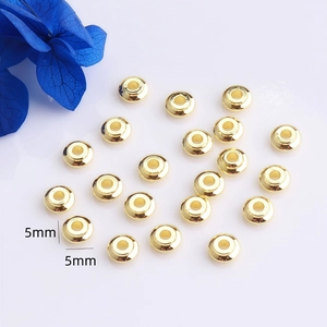 Vista detallada de cuentas espaciadoras planas de 5mm bañadas en oro 14K para joyería