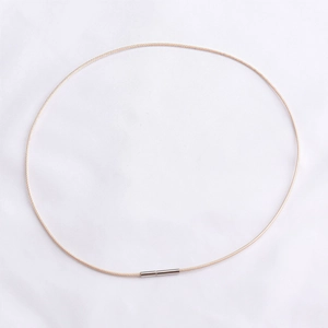 Detalle del cordón de collar tejido en oro rosa con cierre cilíndrico de plata