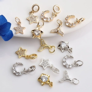 Vue de près de pendentifs en zircon en forme de lune, étoile et queue de poisson 14K