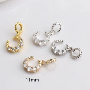 Vue macro détaillée de pendentifs en forme de C 11mm dorés 14K et argentés avec zircons
