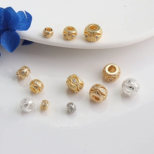 Close-up of 14K gold-filled pave zircon spacer beads with intricate hollow weave texture