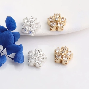 Detailed macro view of 14K gold-filled and silver 5-petal flower beads with inlaid zircon