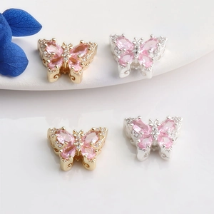Macro shot of 14K gold butterfly beads with pink zircon inlay for jewelry making