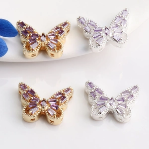 Macro shot of 14K gold-plated butterfly charms with purple zircon inlay and metal luster