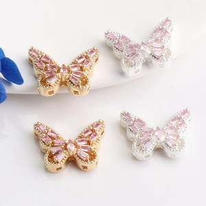 Detailed macro view of 14K gold butterfly pendants with inlaid pink zircon stones