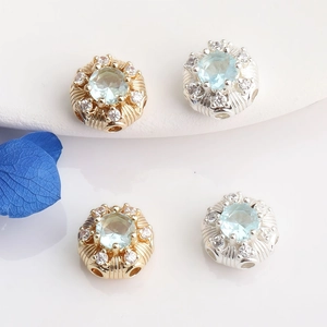 Macro detail of 14K gold plated rectangular spacer beads with inlaid blue zircon stones