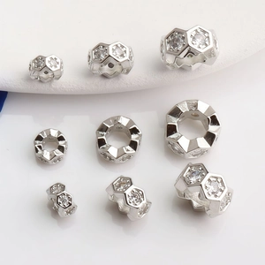 Dettaglio di perline distanziatrici a nido d'ape placcate oro 14K con zirconi incastonati