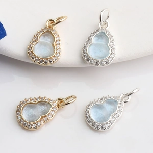 Detailed view of 14K gold-filled Gourd charms with micro-paved zircons and blue gemstones