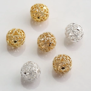 Macro detail of 10mm hollow gold and silver filigree spacer beads for jewelry DIY