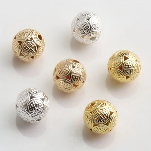 Detailed view of 10mm hollow gold and silver spheres with intricate filigree patterns