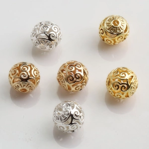 Detailed macro view of 10mm 14K gold-filled hollow beads with intricate scroll patterns
