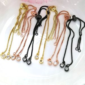 Dettaglio macro di catene box regolabili placcate oro 14K con pendenti in zirconi