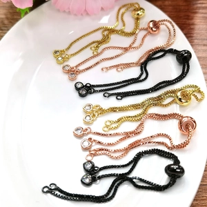 Bracciale a catena regolabile in oro 14K con ciondoli in zircone su un piatto di ceramica