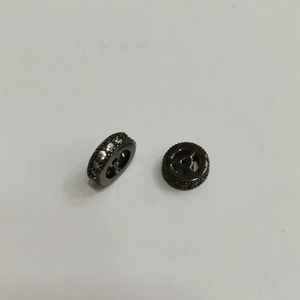 Dettaglio di perla nera placcata con zirconi micro-pavé e design a ruota cava interna