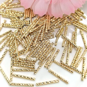 Macro detail of 14K gold filled curved tubes with spiral texture for jewelry making
