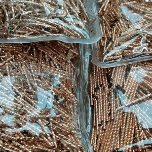 Macro shot of 14K gold-filled twisted tube beads for DIY jewelry making in bulk